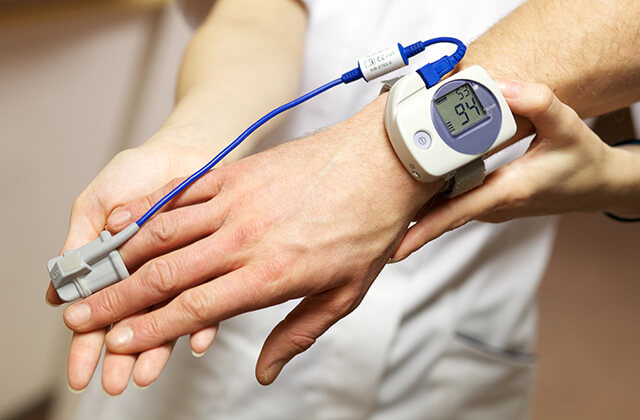 睡眠時無呼吸症候群の検査用センサーを指につけている様子