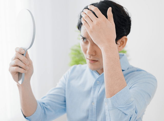 髪の毛を気にする男性